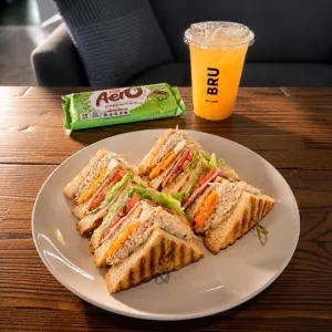 Triple-decker BRU club sandwich with chicken, bacon, egg and salad, served with fries as a combo in Pattaya